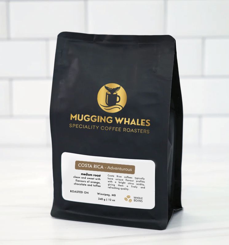 Mugging Whales coffee packaging with a gold whale and coffee cup identity on a black bag